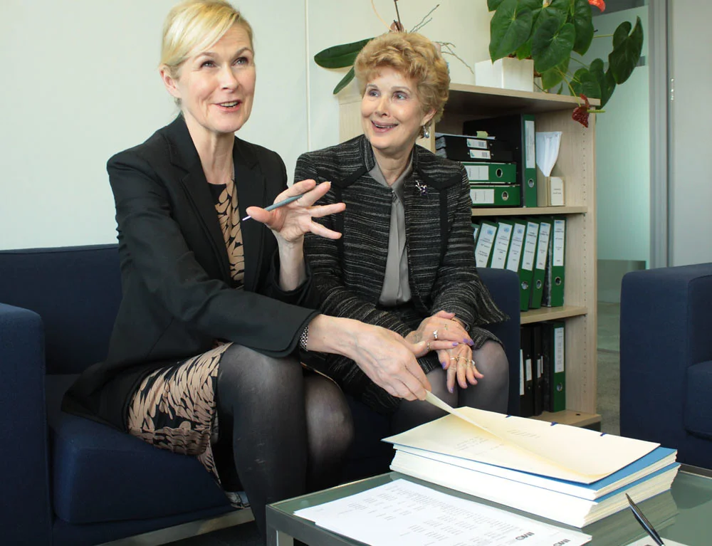 Two people signing the articles of association of a newly created company