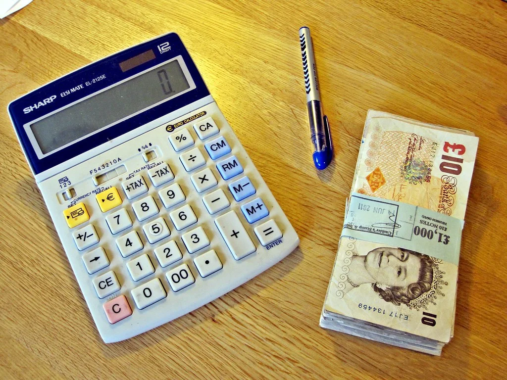 Calculatrice posée sur des documents financiers pour illustrer la facturation d'entreprise