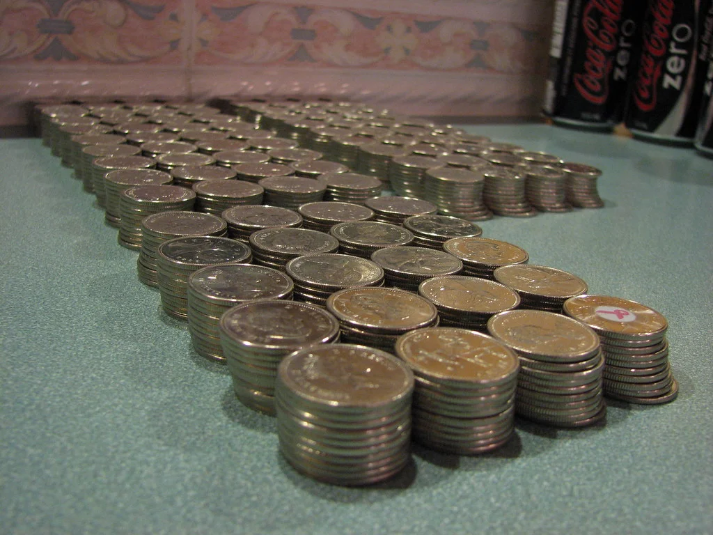Pile de pièces et de billets illustrant le calcul d'un salaire